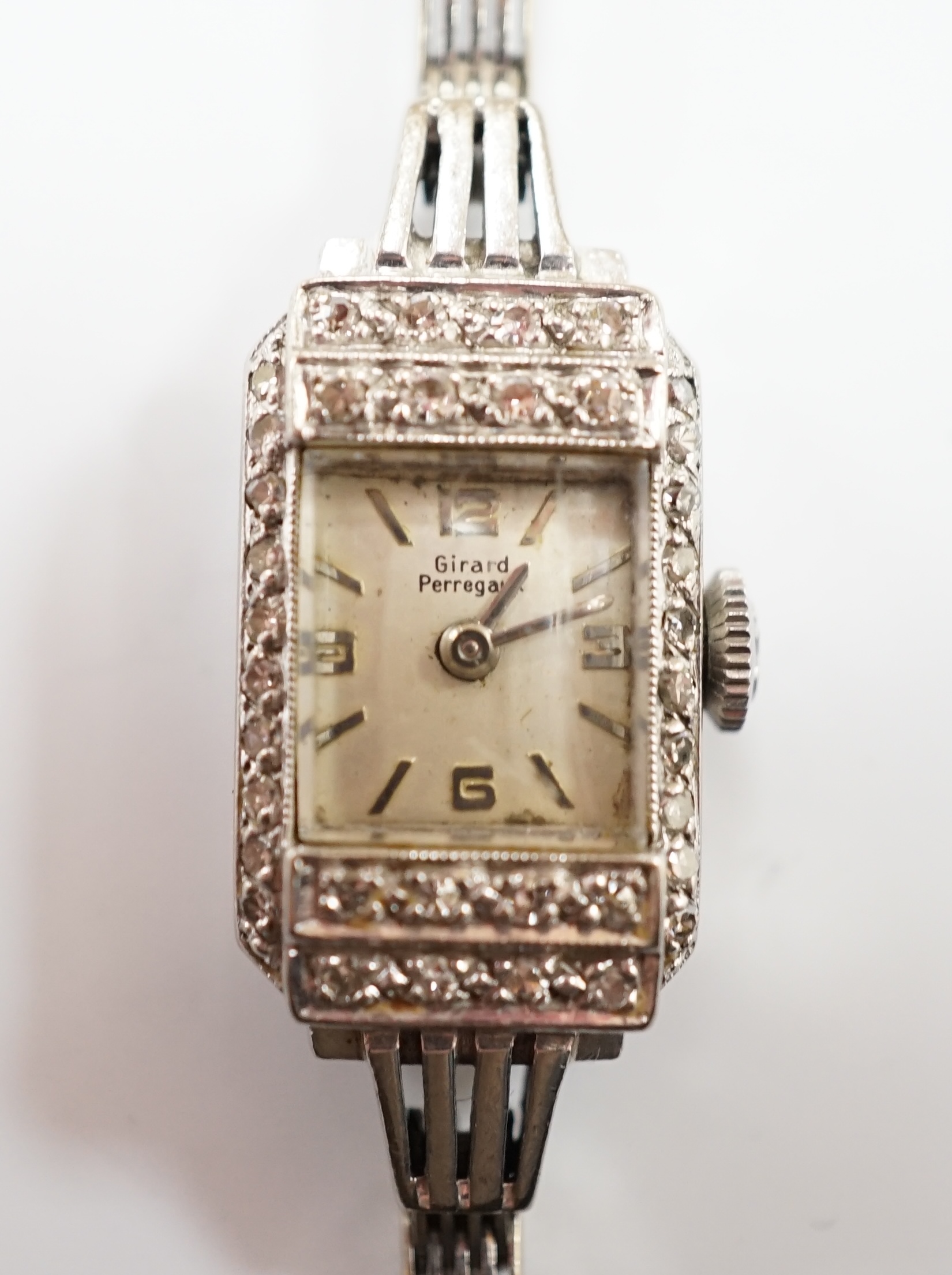 A lady's Girard Perregaux white metal and diamond cluster set manual wind cocktail watch, on a 9ct white gold bracelet, overall 16.5cm, gross weight 17.8 grams.